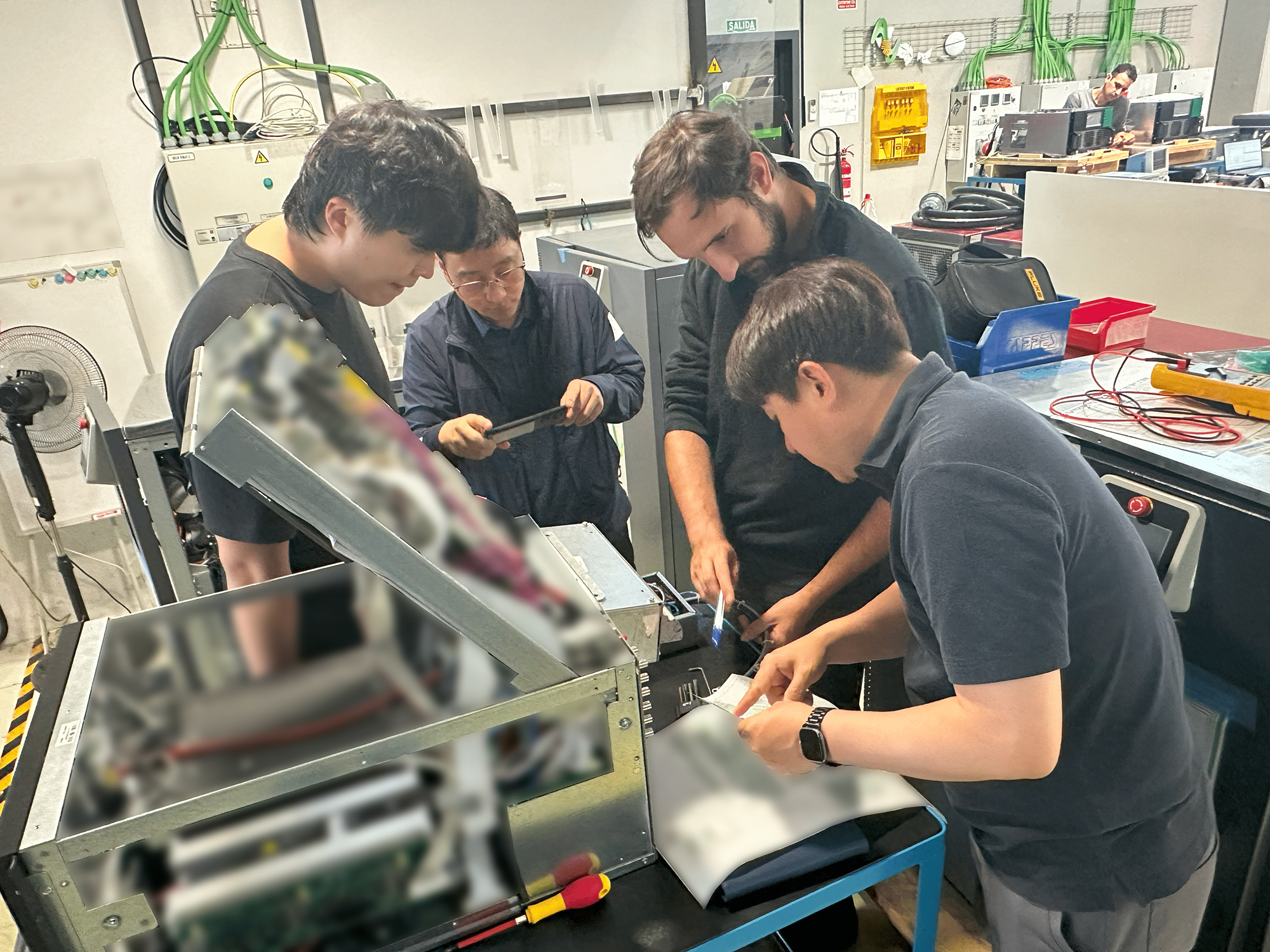 KMi engineers analyzing Cinergia equipment during hands-on technical training in the workshop.